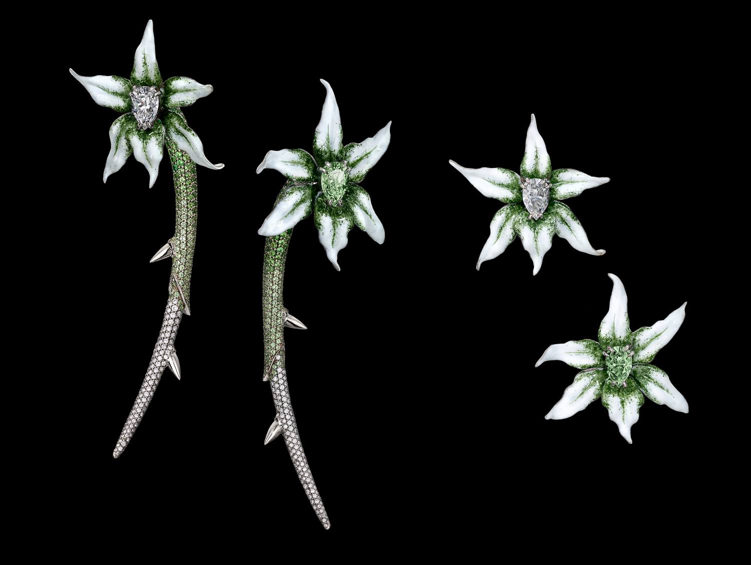 Silver and green floral star-shaped jewelry set against a black background.