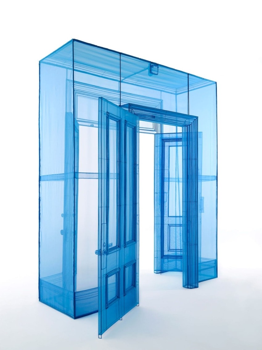 Blue translucent fabric structure resembling a doorframe and door, standing against a white background.