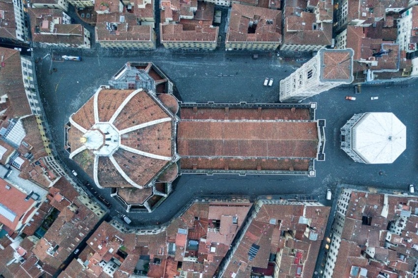 Aerial view of a historic dome, surrounding buildings, and a city square with a tower and octagonal structure.