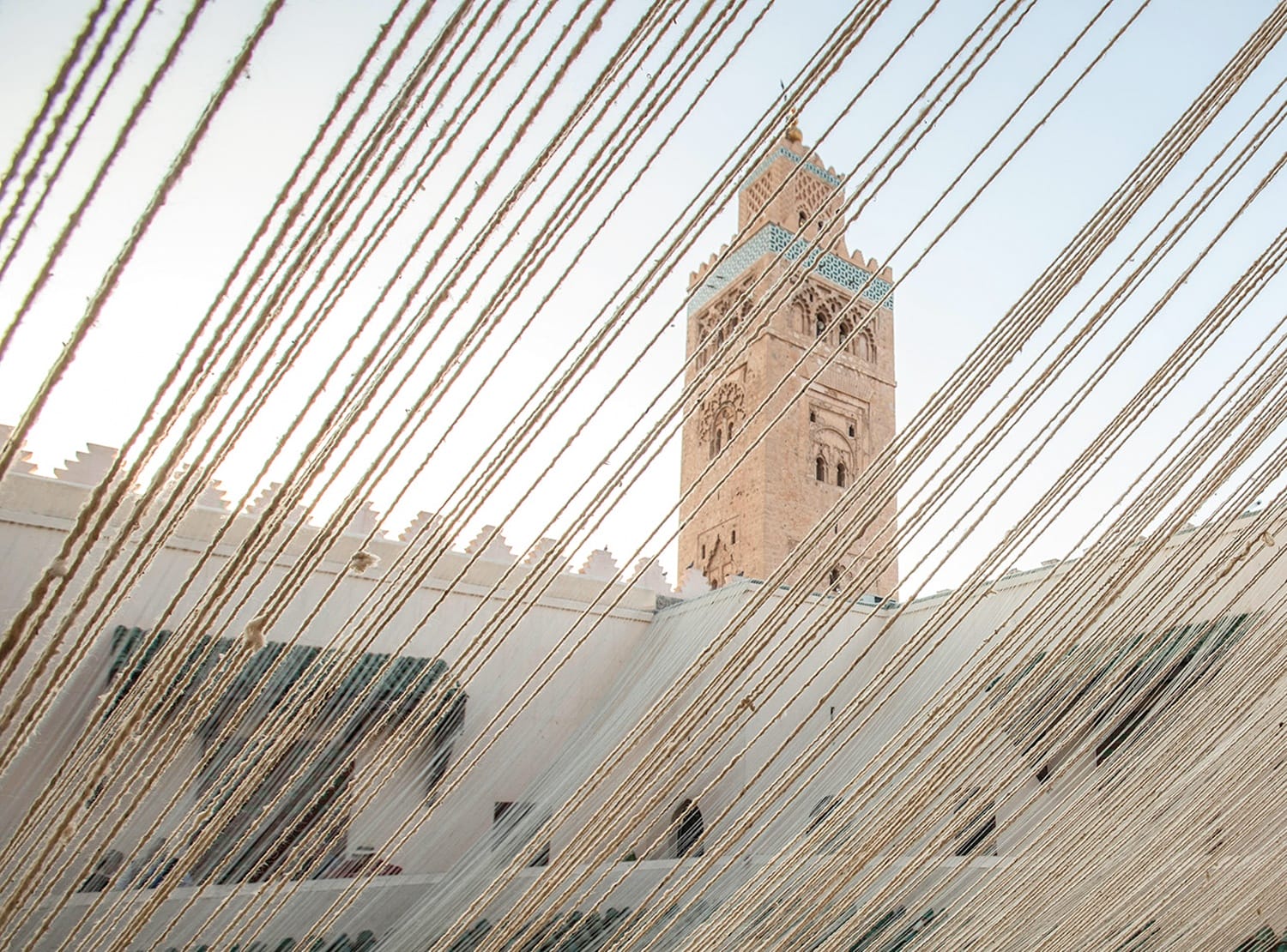 Strings framing a historical tower under a clear sky in an architectural setting.