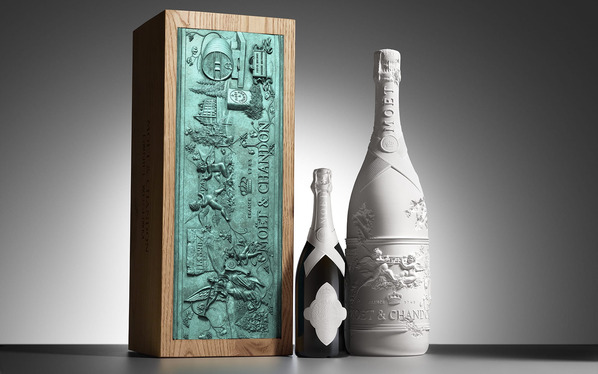 Champagne bottles with intricate packaging, including one wooden box and two elegantly designed bottles.