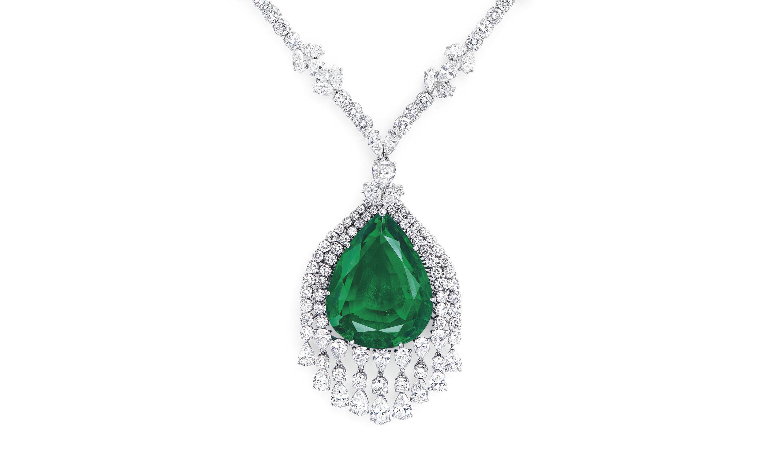 Emerald and diamond necklace with teardrop gemstone and intricate detailing on a white background.