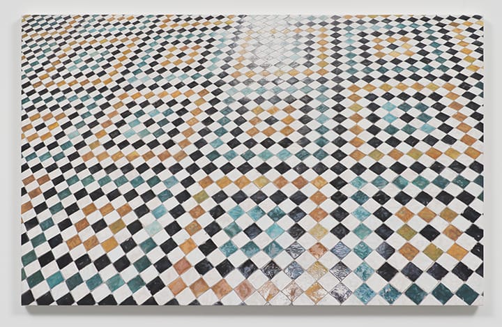 Intricate geometric mosaic with a pattern of black, white, blue, and brown tiles arranged in circular and diamond shapes.