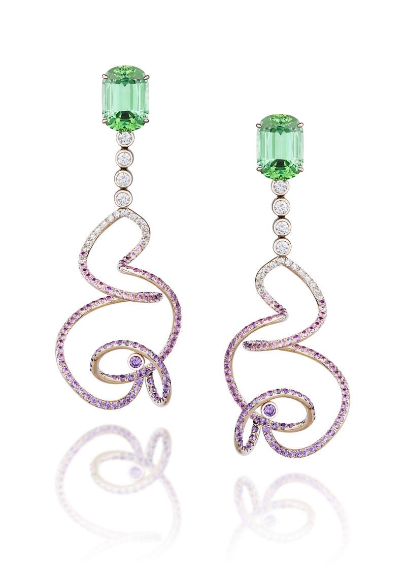 Elegant green gemstone earrings with purple and white diamond swirl design against a white background.