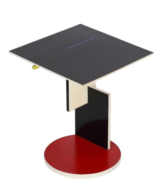 Modern geometric side table with a black square top, white and black central support, and red circular base.