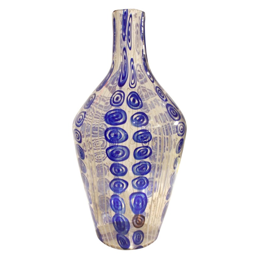 Tall glass vase with abstract blue spiral patterns on a translucent beige background.