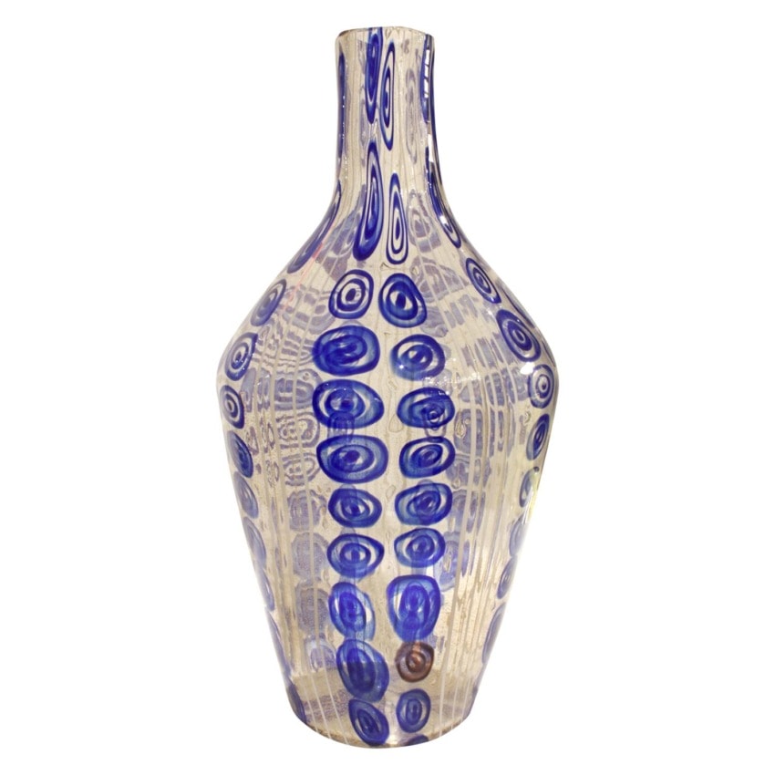 Tall glass vase with abstract blue spiral patterns on a translucent beige background.