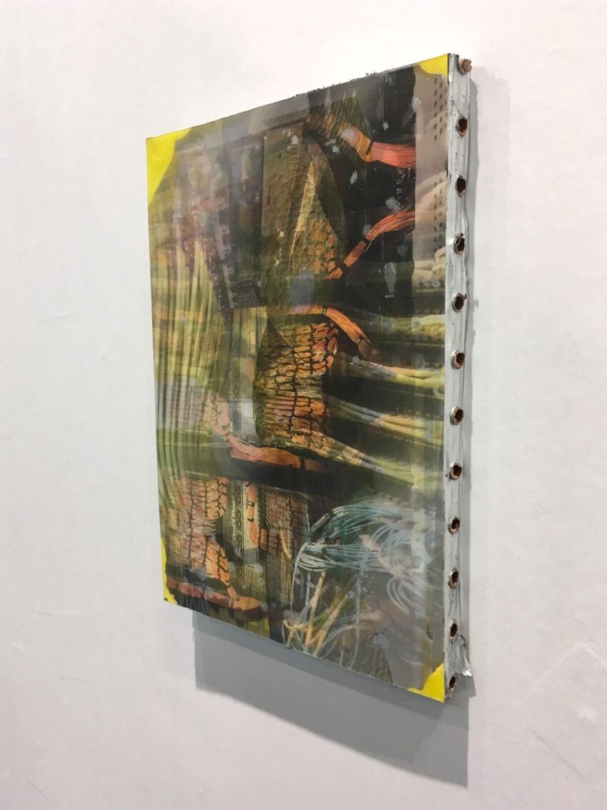 Side view of a mixed media artwork on canvas with abstract patterns, rough textures, and vibrant colors against a white background.