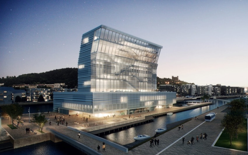 Modern waterfront building with unique architecture at dusk, surrounded by people, trees, and boats on a canal.