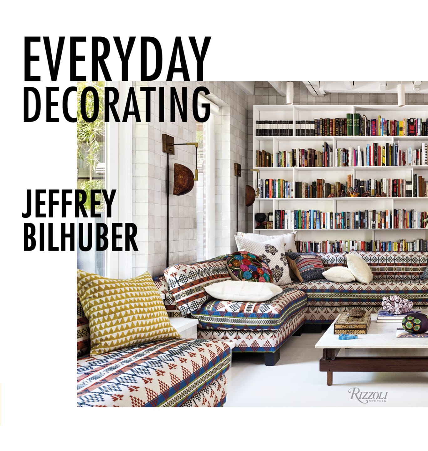 Cozy living room with patterned sofas, bookshelves, and decorative pillows, featured in "Everyday Decorating" by Jeffrey Bilhuber.