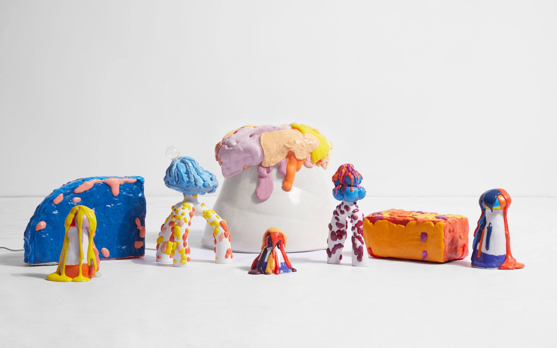 Colorful abstract sculptures with bright, melted textures displayed on a white background.