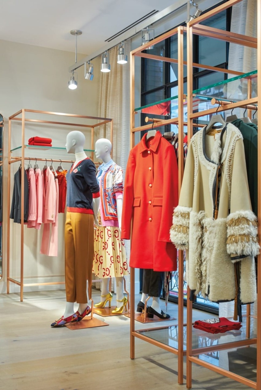 Fashionable clothing display in a boutique featuring colorful outfits on mannequins and racks in a stylish setting.