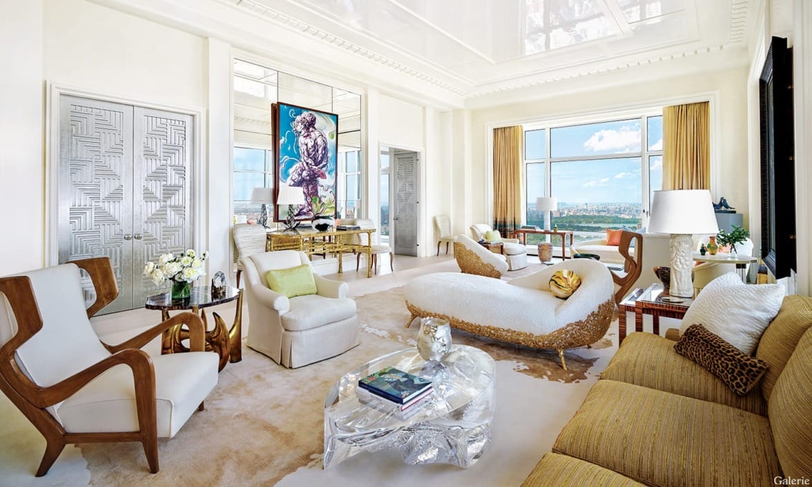 Elegant living room with modern furniture, large windows with a city view, and eclectic decorative elements.