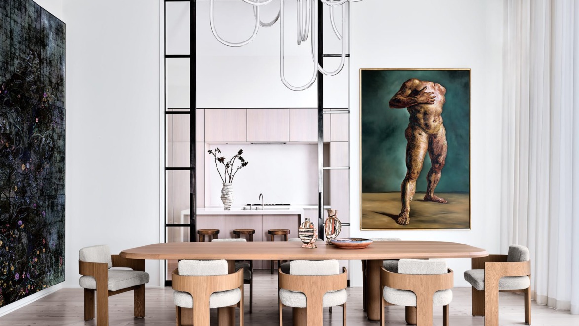 Modern dining room with wooden table, chairs, and abstract artwork on walls. Bright lighting enhances the minimalist design.