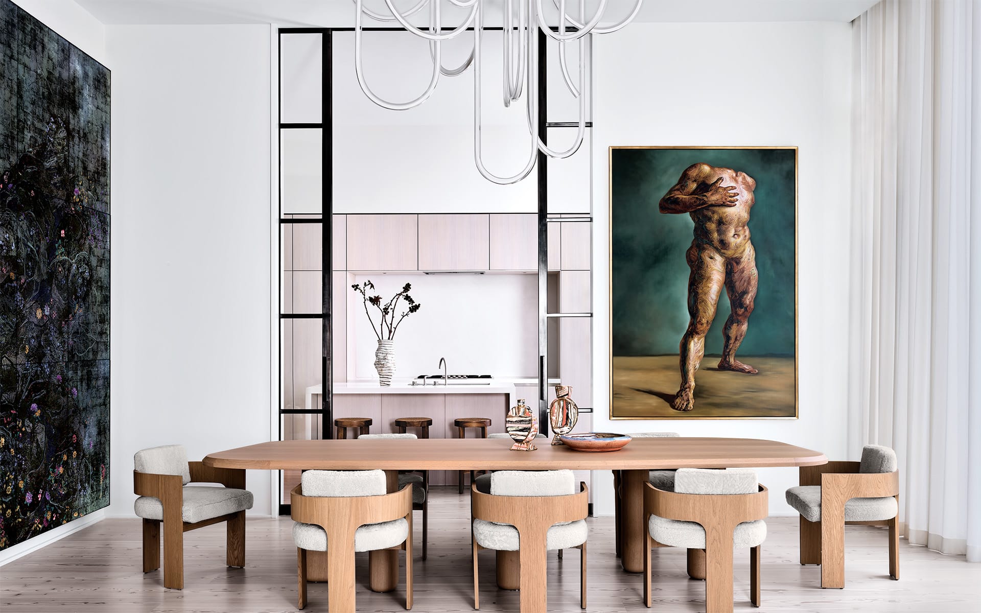 Modern dining room with wooden table, chairs, and abstract artwork on walls. Bright lighting enhances the minimalist design.