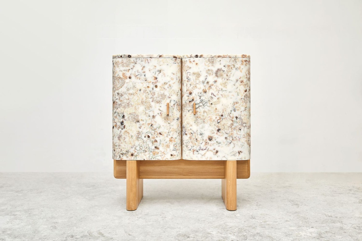 Modern two-door cabinet with a stone-like textured surface and wooden legs against a plain background.