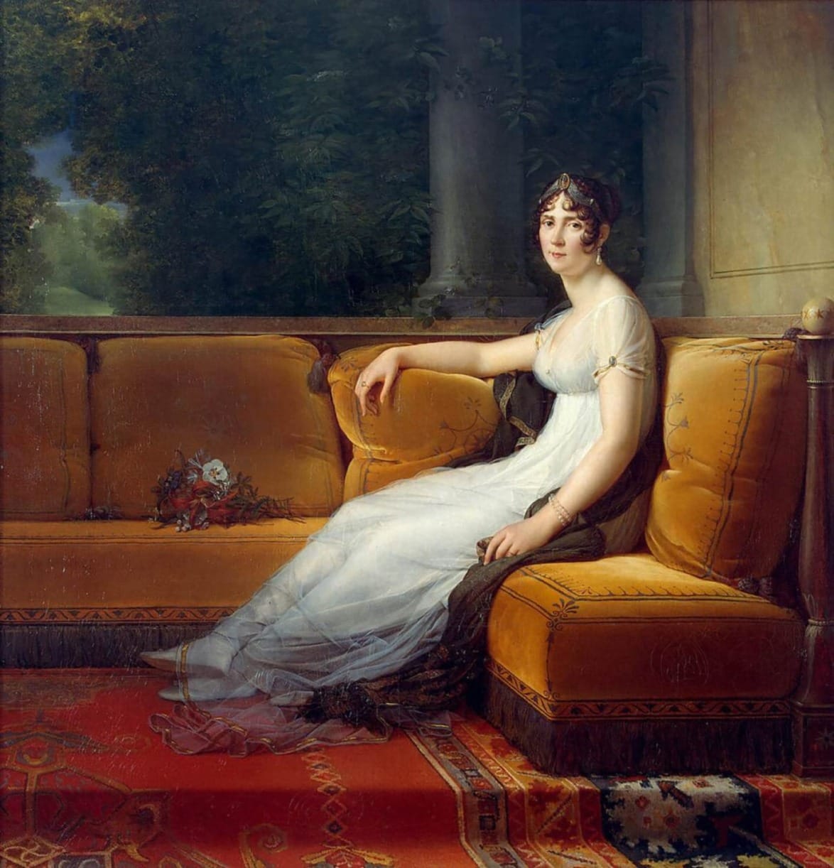 Woman in a white dress sitting on a yellow sofa in a historical setting, surrounded by a lush garden background.