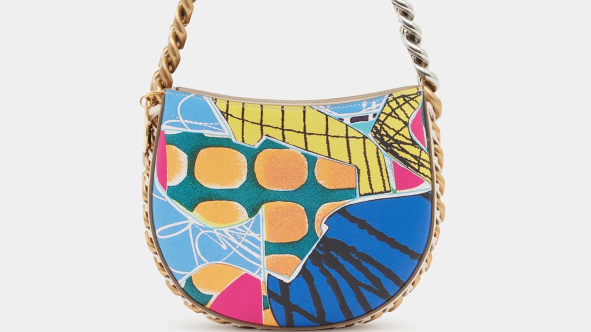 Colorful handbag with abstract geometric patterns and a gold chain strap.