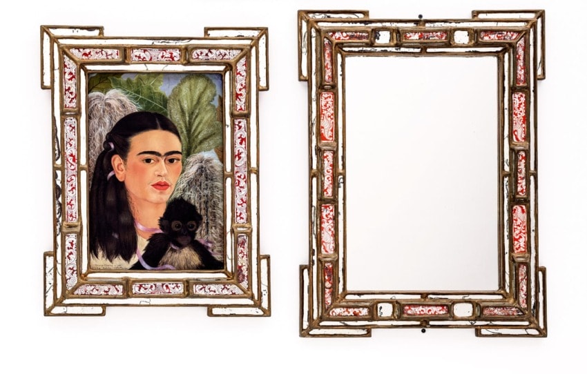 Framed portrait of a woman with a monkey next to an empty ornate mirror on white background.