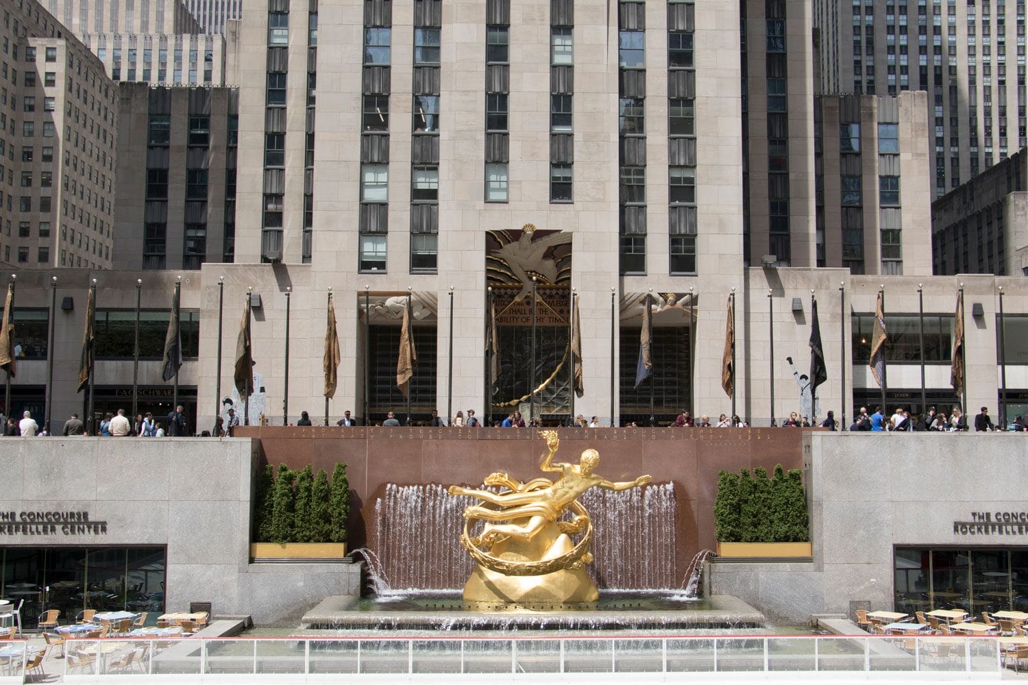 Prometheus statue and fountain at Rockefeller Center with surrounding buildings and people in background.