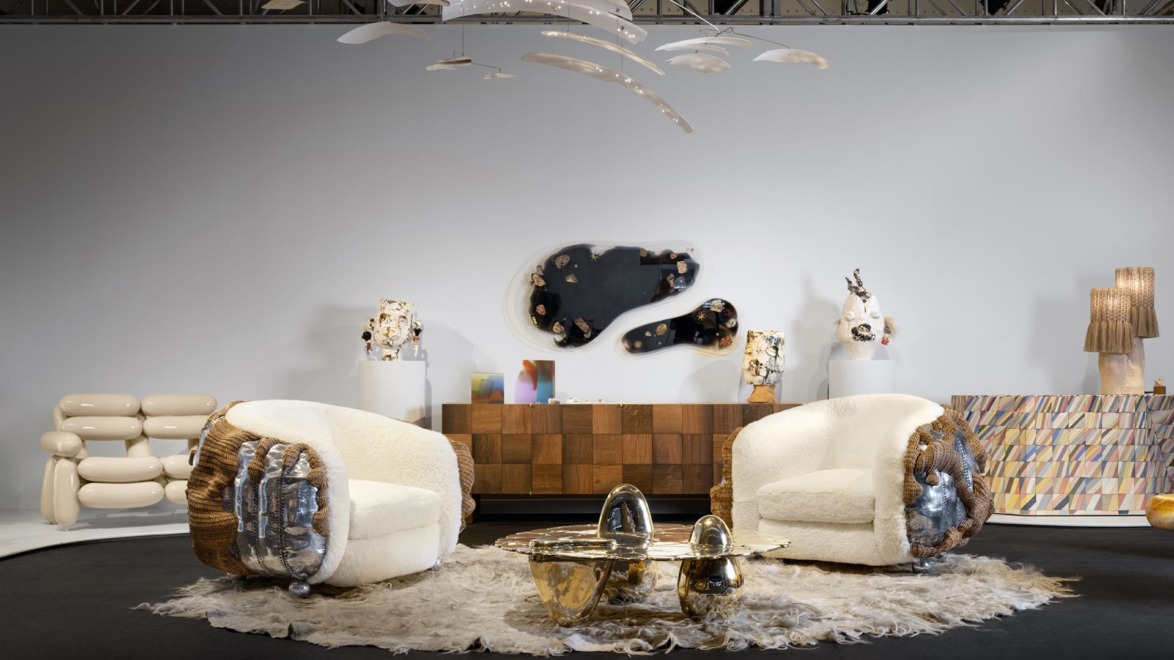 Modern furniture showroom featuring two round chairs, unique coffee table, abstract wall art, and decorative lighting fixtures.