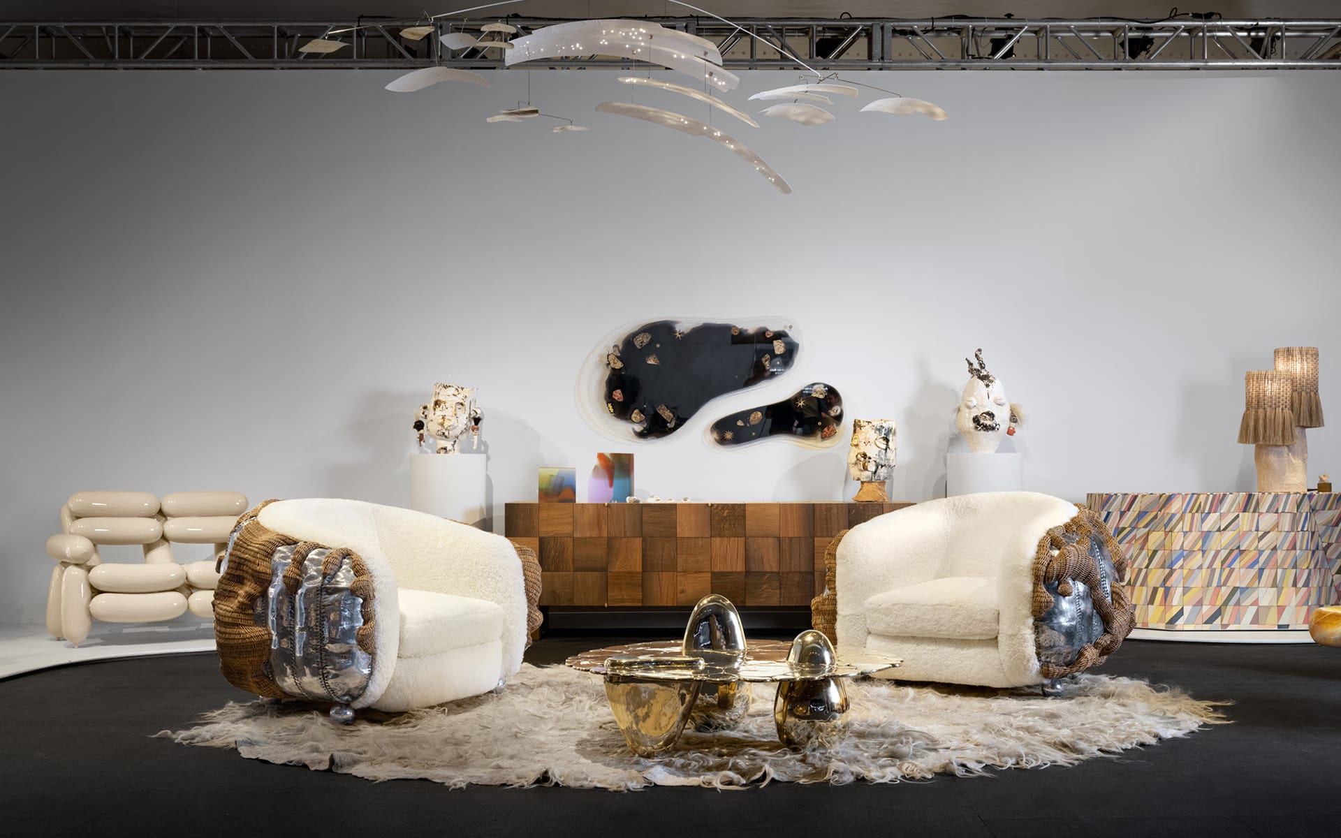 Modern furniture showroom featuring two round chairs, unique coffee table, abstract wall art, and decorative lighting fixtures.
