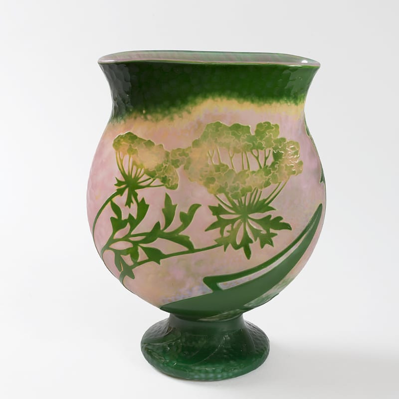 Art Nouveau vase with floral design in green and pink tones on a white background.