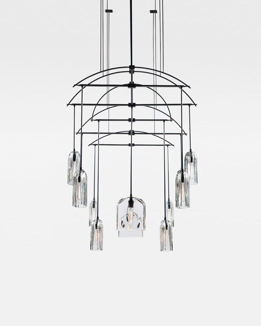 Modern chandelier with multiple glass pendants and black metal frame hanging against a plain white background.