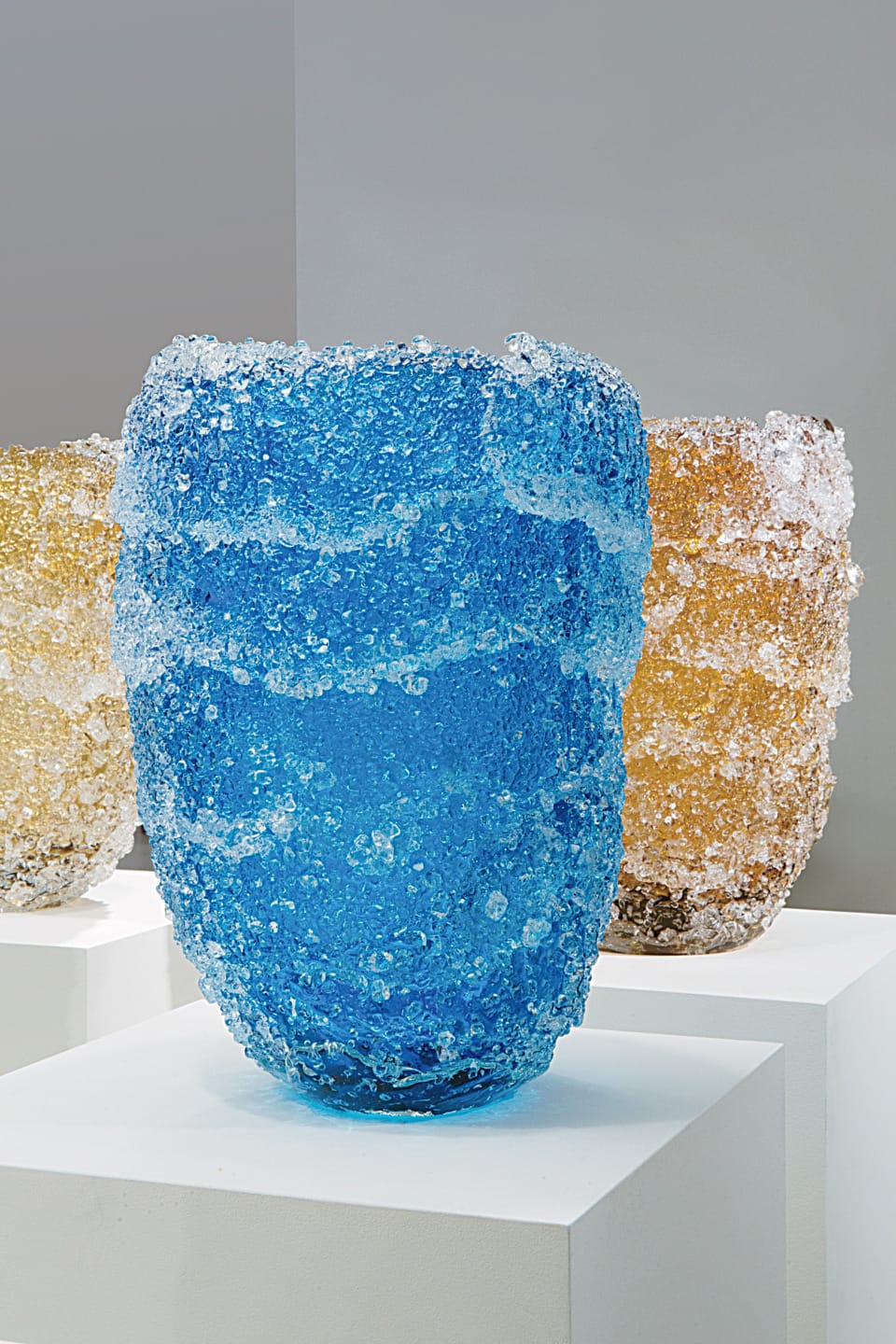 The vases are realized by fusing glass fragments onto a smooth glass surface.
