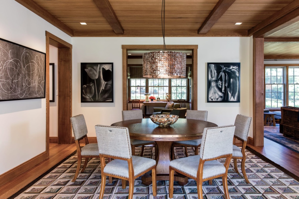 A shimmering light fixture from the McEwen Lighting Studio, in Berkeley, California, dangles in the dining room. American artist Elliott Puckette painted the abstract work hanging on the left wall.