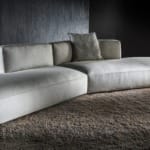 Modern sectional sofa on plush beige rug in dimly lit room