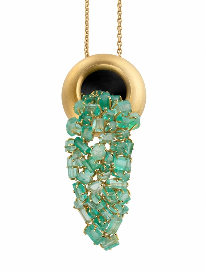 Gold pendant necklace with clustered green crystals and a round black accent.