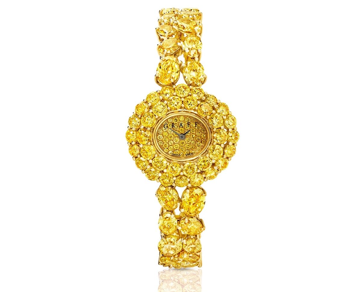 Luxury gold watch adorned with embedded yellow gemstones, featuring an intricate, elaborate, and decorative design.