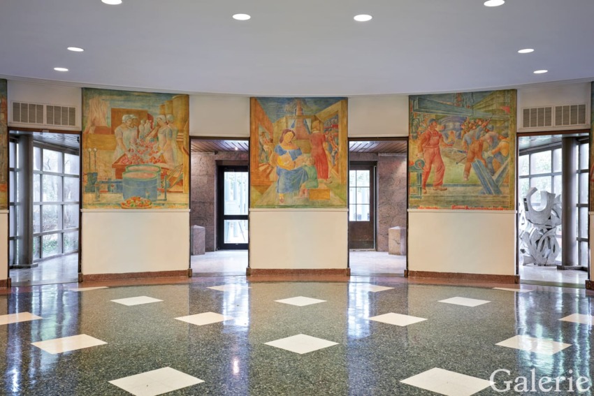 Round room with large murals depicting historical scenes and a polished tiled floor.