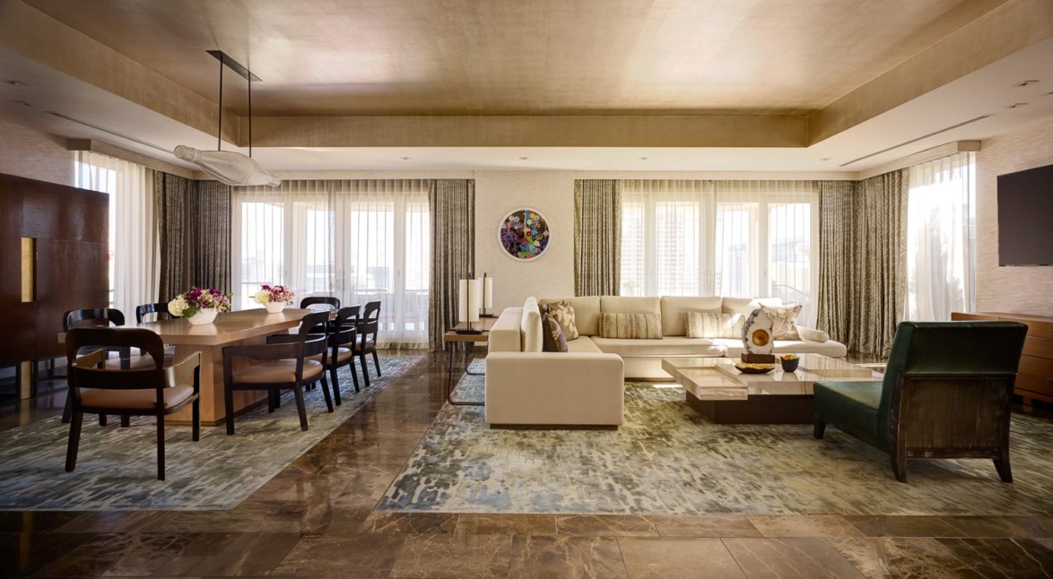 Luxurious modern living and dining area with elegant furniture, large windows, and decorative accents.