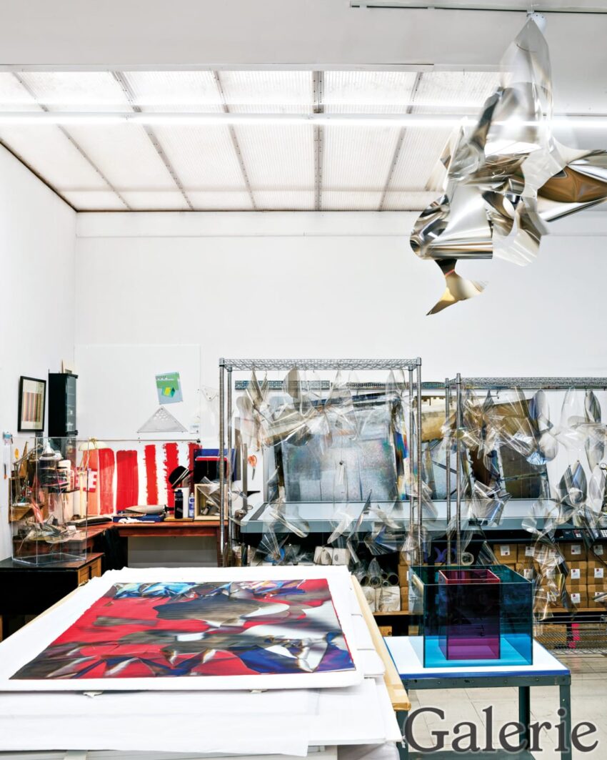 Art studio with vibrant paintings, metal sculptures, and artworks in progress, showcasing a creative and dynamic space.