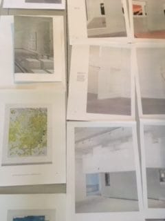 Scattered art prints on a table showcasing abstract and minimalist designs.