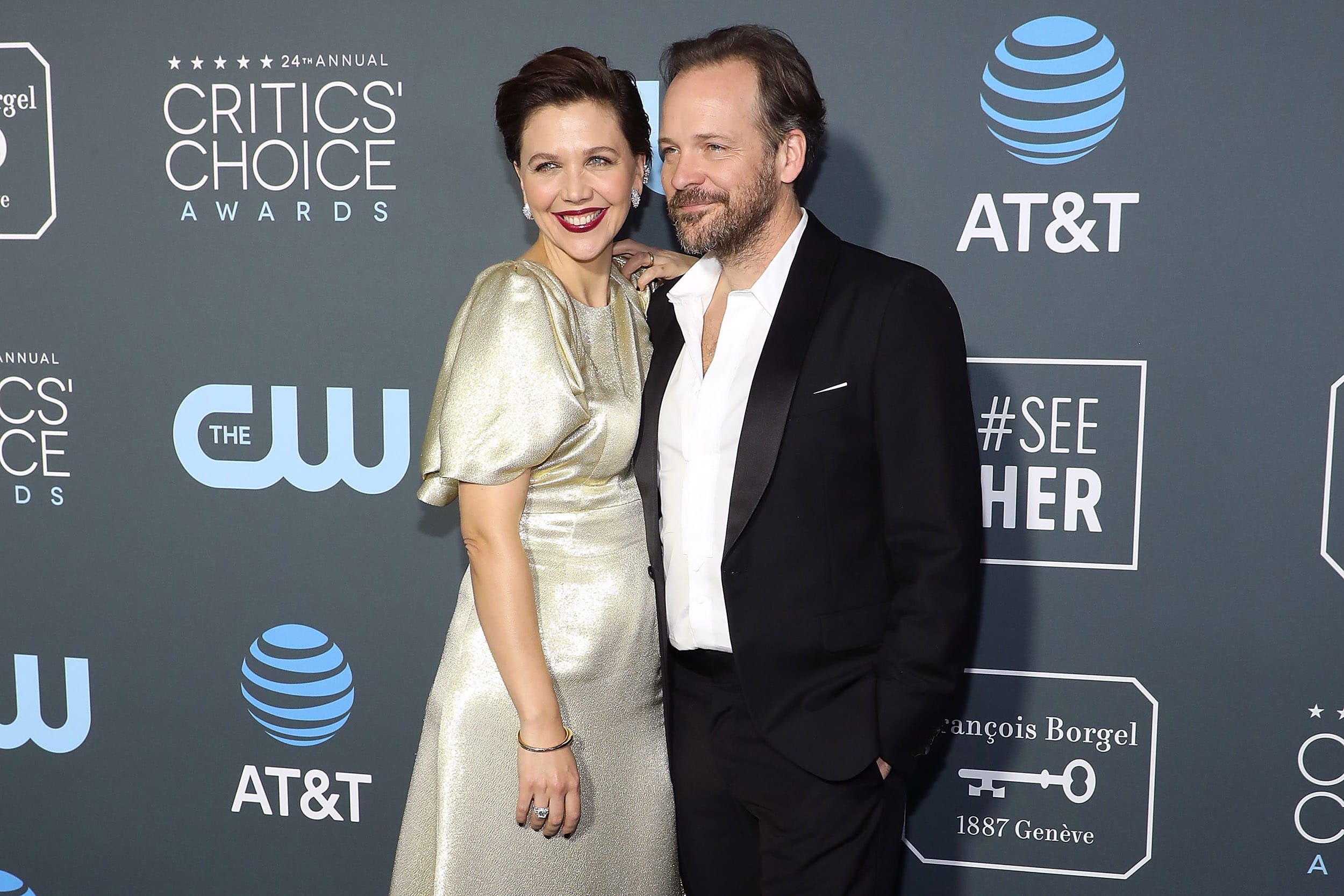 A man and woman posing together on the red carpet at the 24th Annual Critics' Choice Awards, holding each other and smiling.