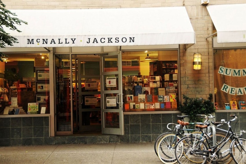 Bookstore exterior with open doors, books displayed inside, and two bicycles parked outside.