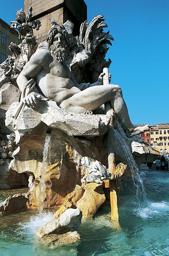 Fountain of the Four Rivers statue with flowing water in a sunny piazza setting, featuring intricate stone carvings.
