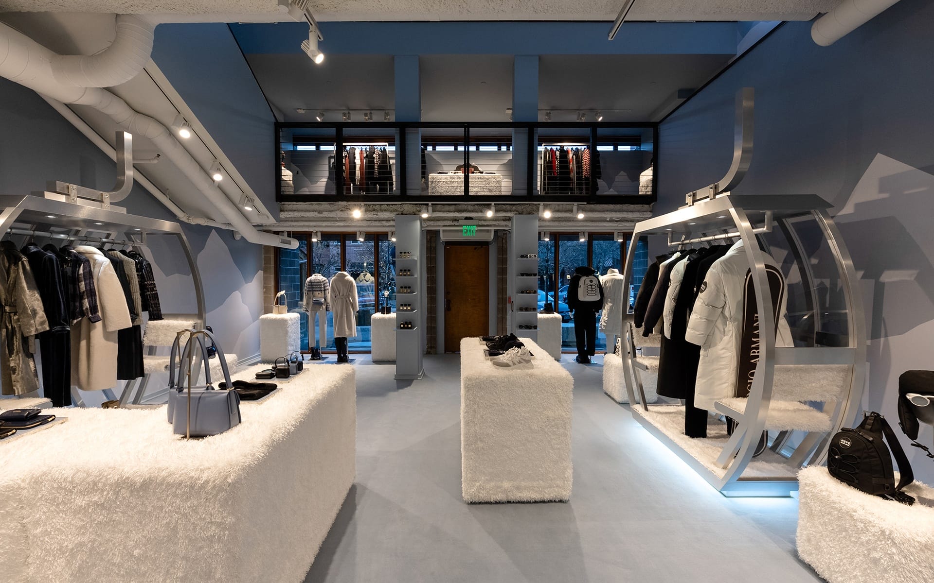 Modern clothing store interior with stylish winter wear displayed on racks and shelves, featuring minimalist decor.