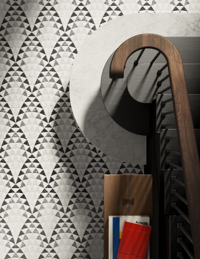 Patterned wall with geometric shapes, a spiral staircase, and a wooden rack holding colorful books and magazines.
