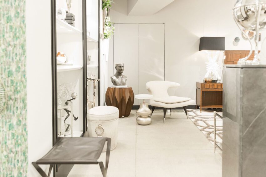 Modern living room with stylish furniture, abstract sculpture, shelves, and decorative accents in a cozy, well-lit space.