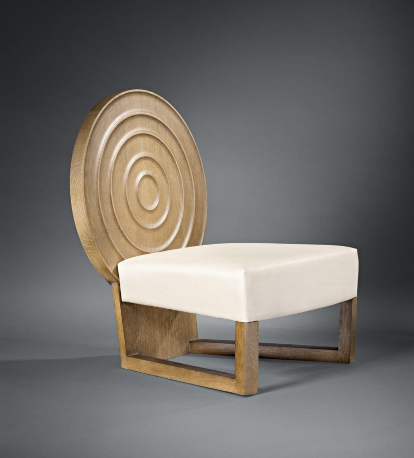Modern wooden chair with circular back design and white cushioned seat against a gray background.