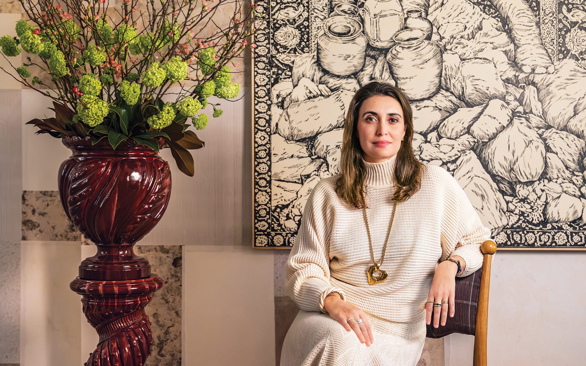 Laura Gonzalez at her Paris gallery with her Mawu chair before an artwork by Maurizio Donzelli.
