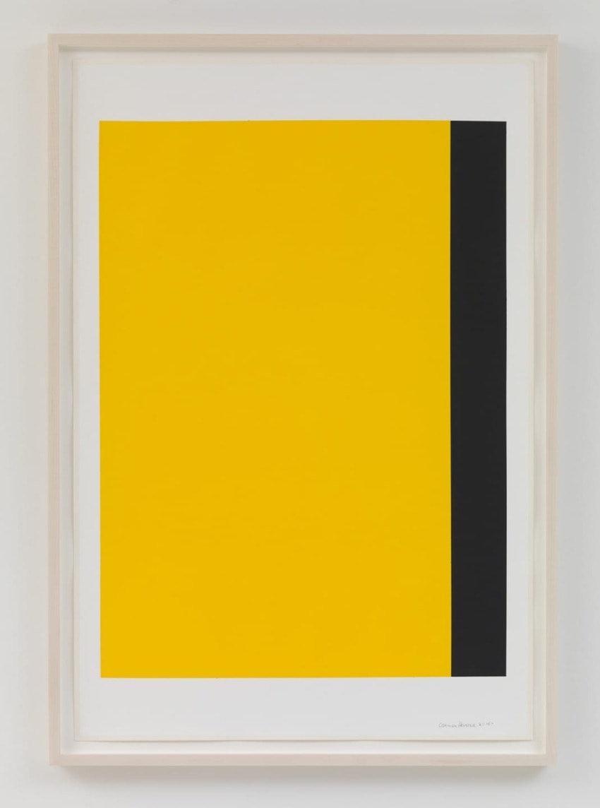 Abstract artwork featuring a large yellow rectangle with a vertical black stripe on the right, framed and hung on a white wall.