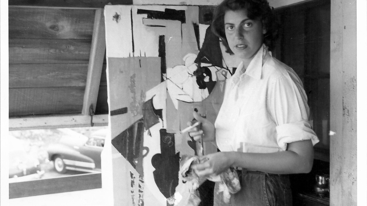 Person painting an abstract artwork on canvas in a studio setting.