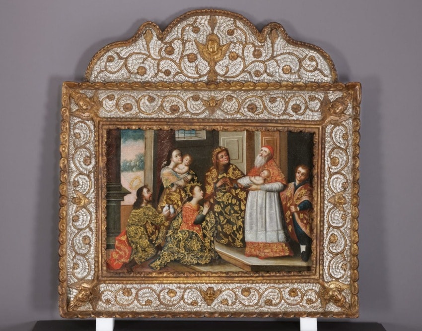 Ornate framed painting depicting a historical family scene with richly dressed figures engaged in conversation indoors.