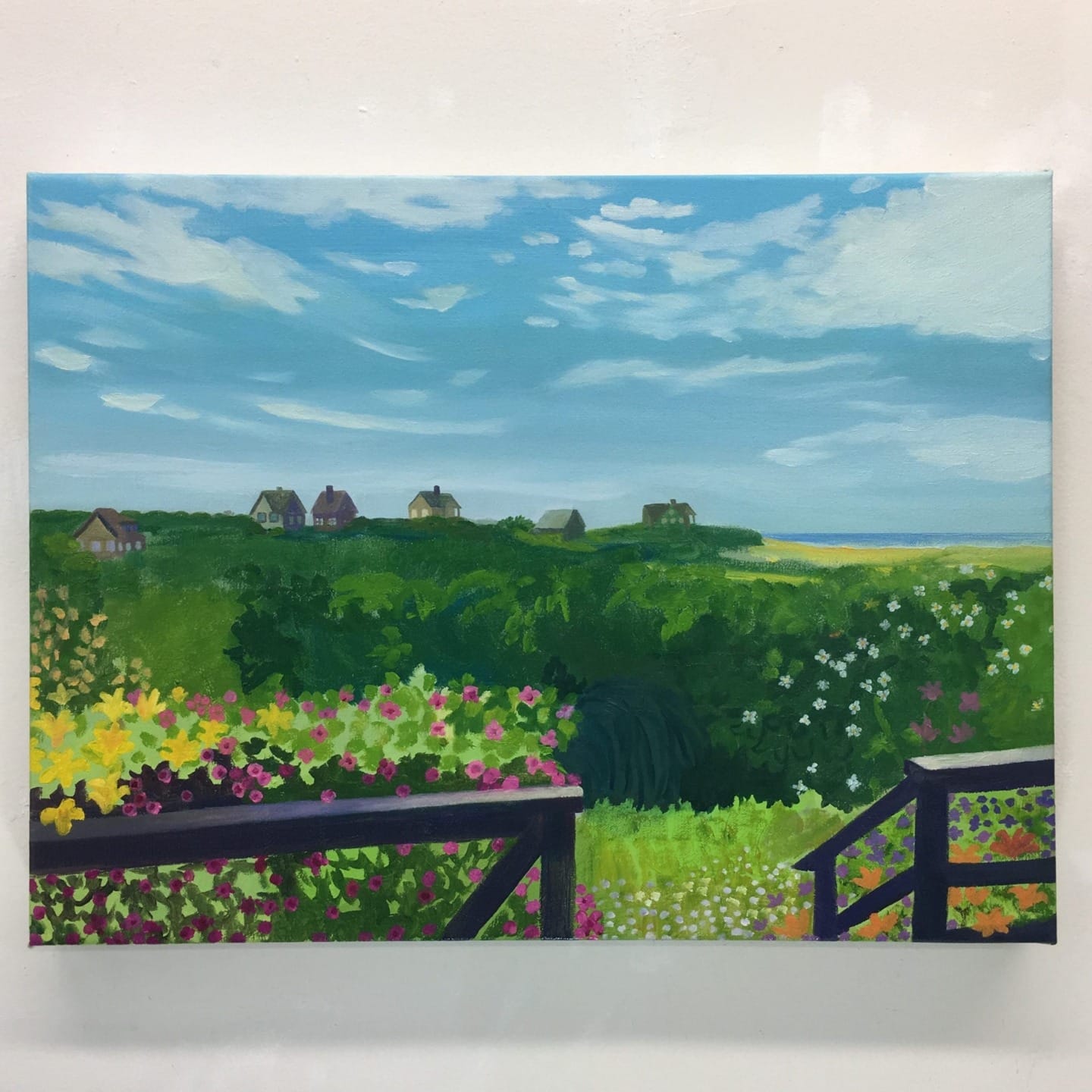 Painting of a vibrant landscape with a wooden fence, colorful flowers, green fields, and distant houses under a blue sky.