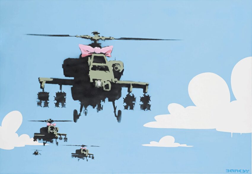 Helicopters flying in blue sky with clouds, main helicopter adorned with a pink bow.